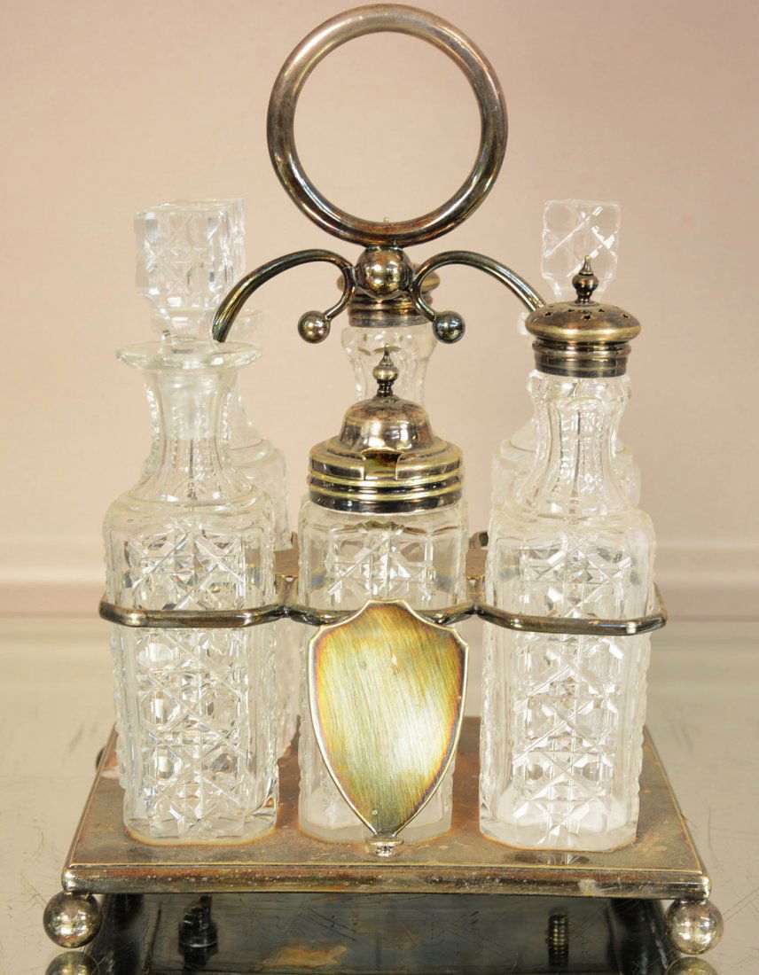 English Victorian Silver-Plated Six Bottle Cruet Stand: English Victorian Silver-Plated and Cut Glass Six-Bottle Cruet Stand his British antique cruet or caster set is complete with six cut glass bottles on a silver plated rectangular stand on ball feet. T