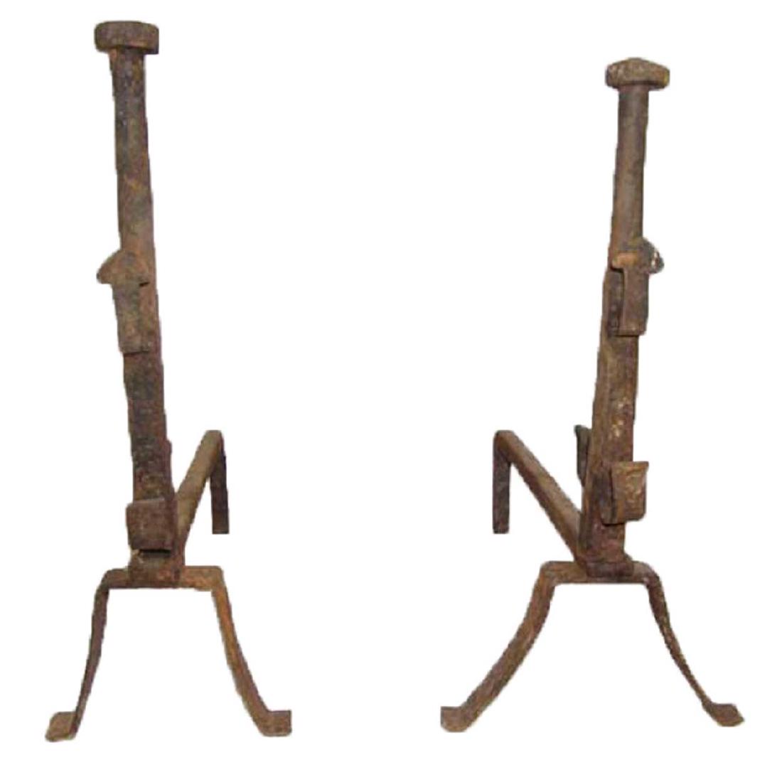 Pair of French Provincial Wrought Iron Andirons: This pair of antique, French provincial andirons were fashioned in tall and slender form, topped by penny finials and resting on horizontal bars that turn down into splayed legs with flat feet. DATE 1