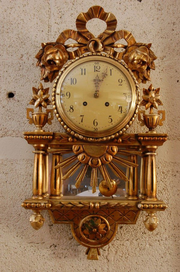 Swedish Gilted & Wood wall clock with Floral Ribbo: Swedish Gilted & Wood wall clock with Floral Ribbon crest, 4 columns & Sunburst mirror. Panel in base. 26 x 14 x 4 ca. 1900