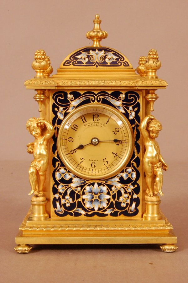 Howell James & CO. Miniature Clock with Putti. Di: Howell James & CO. Miniature Clock with Putti. Dial marked "Howell & James London to the Queen", dore bronze case, enamel painted.