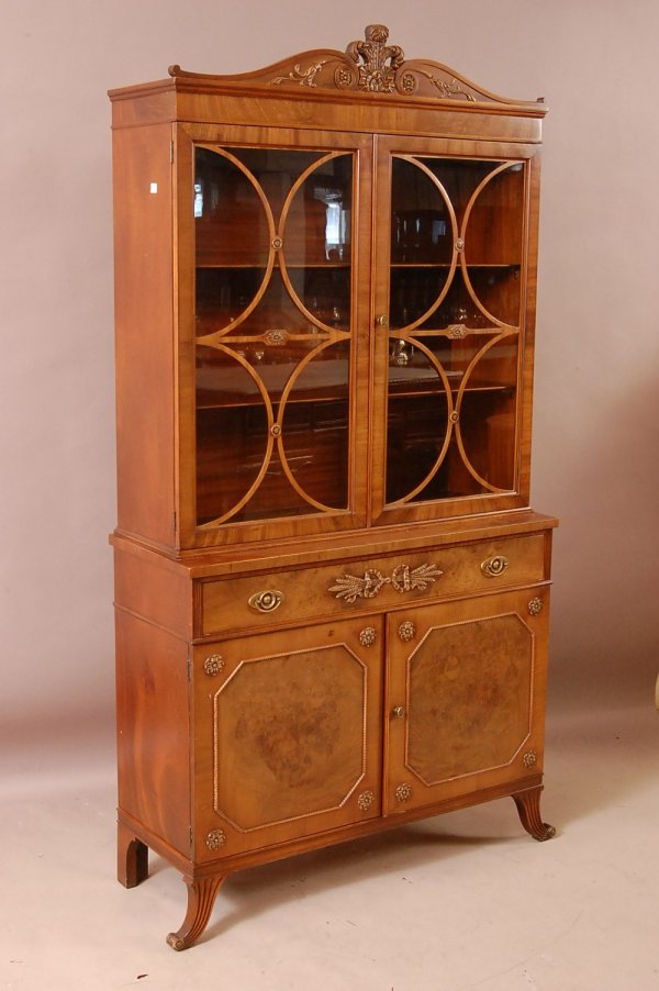 Sheraton Style Walnut china cabinet, floral carved: Sheraton Style Walnut china cabinet, floral carved arched crest. Overlay panels in 2 glass doors. 1 drawer, 2 doors in base with burled panel. 79"t x 41"w x 15"d ca. 1920