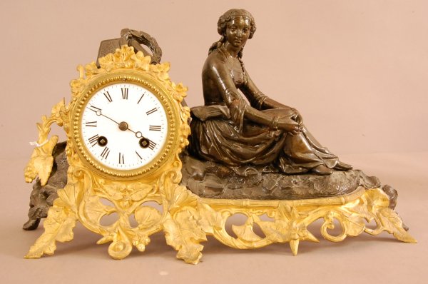 French Figural Bronze Mantel Clock. Seated Woman, : French Figural Bronze Mantel Clock. Seated Woman, Book Scroll on top of clock. Dore Bronze base with leaves & flowers. Porcelain Dial. Movement signed Japy Freres. 9"t x 15"w x 4"d. Ca. 1870.