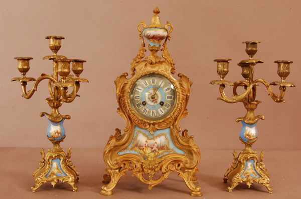 French Dore Bronze Louis XVI Serves 3 Piece Clock: French Dore Bronze Louis XVI Serves 3 Piece Clock set. Porcelain Face with courting scene. Plaque in base of clock. Floral & leaf decorations around clock. Blule enameled porcelain vase. Black starr &