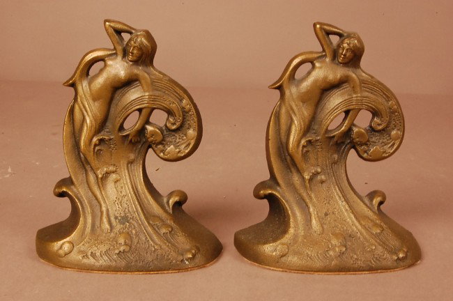 Pair of Art Noveau style cast iron bookends. Stand: Pair of Art Noveau style cast iron bookends. Standing nude lady. Marked Water Sprite #604. 5 1/2" t x 4 1/2"w x 2"d.