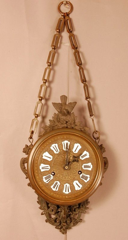French Cartel wall clock with bird & nest on crest: French Cartel wall clock with bird & nest on crest, Porcelain Roman numbers on embossed brass face. Time & strike. 23" t x 17 1/2" w x 5 1/2" d Ca. 1900