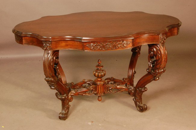Rococo Victorian Walnut Parlor table with turtle s: Rococo Victorian Walnut Parlor table with turtle shape top, carved skirt and apron with drawers on each side, open carved stretchers with turned finial in center on 4 carved legs. 28" t x 50" l x 33" 