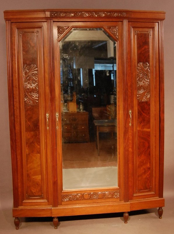French Art Deco style Walnut 3 door armoire. Flor: French Art Deco style Walnut 3 door armoire. Floral caring on burled panes on top & door. Center Door mounted with beveled mirror. Ca. 1920