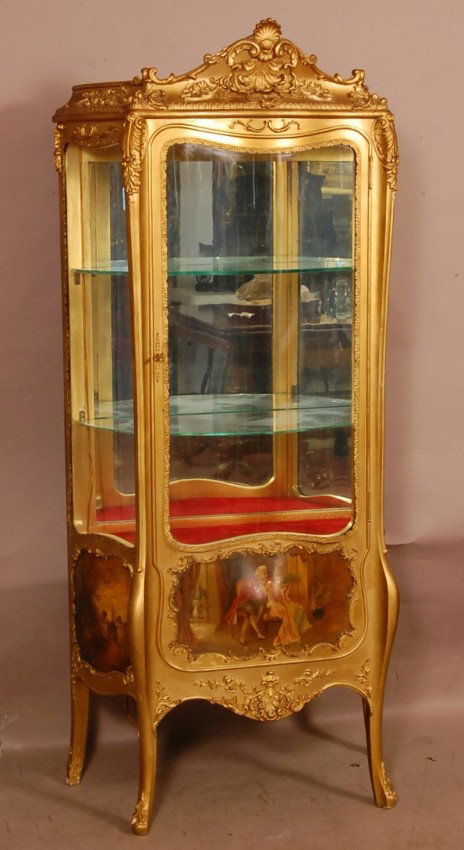 Verne Martin Style Louis XV Gilded Vitrine, Shel: Verne Martin Style Louis XV Gilded Vitrine, Shell carved crest. 3 serpentine glass sides. Mirror on back, bronze trim on doors. 3 Scenic hand painted bombay panels on bottom of cabinet. 30" w x 16"d x