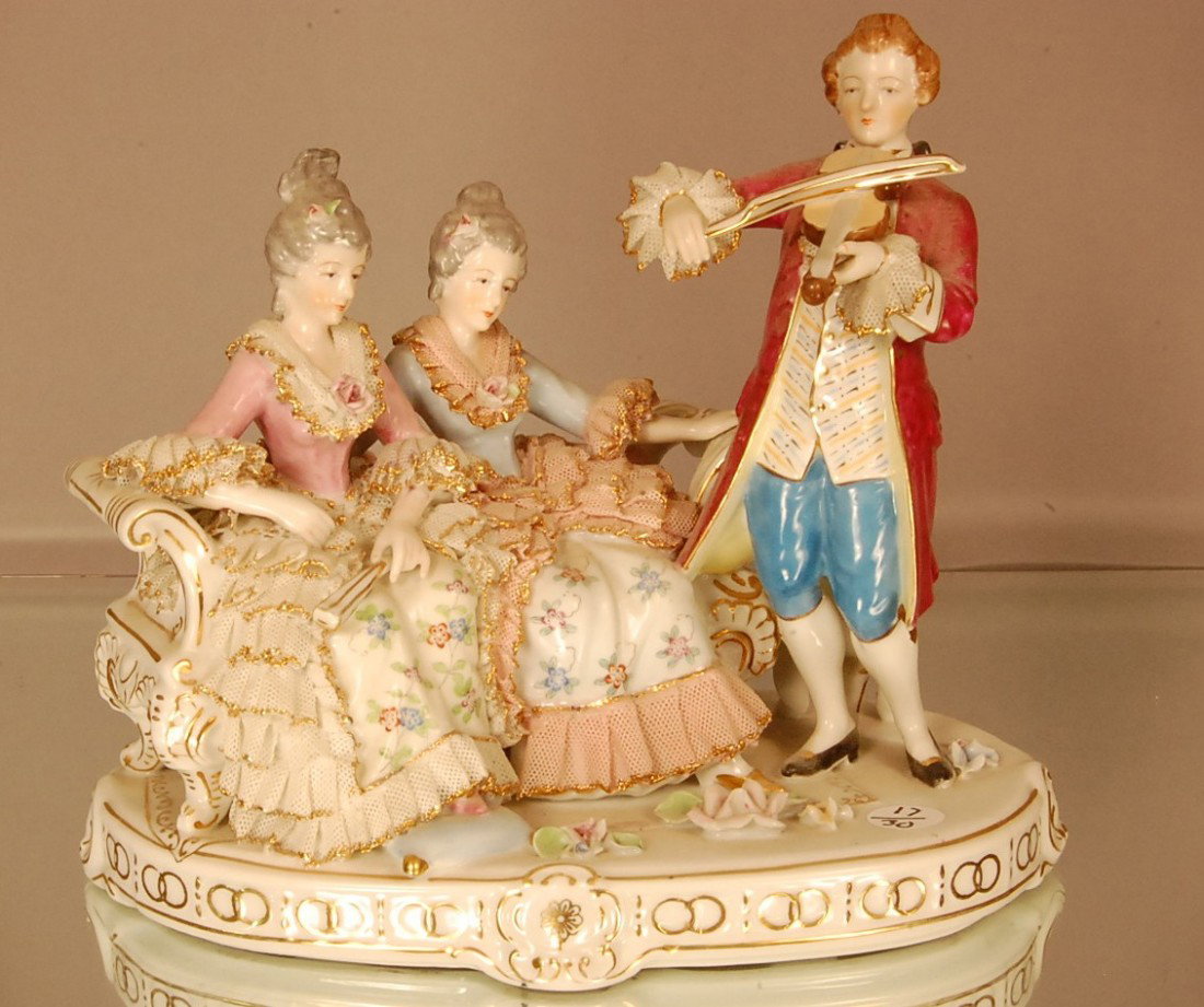 Dresden style statues 2 ladies seated on bench se: Dresden style statues 2 ladies seated on bench serenaded by man wit violin. 10" t x 11" w x 6" d Ca. 1920