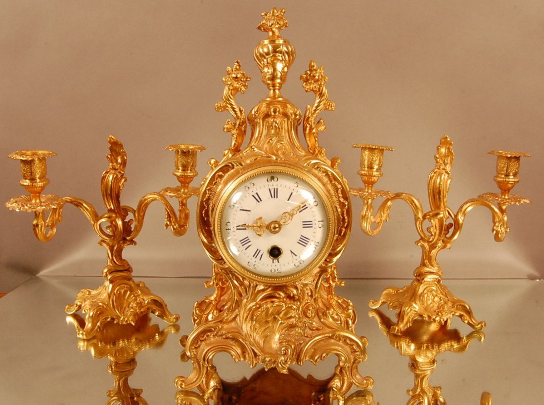 French Louis XV style Dore Bronze 3 Piece Clock Se: Floral Decorated clock case with urn shaped finial, cornucopia supports on sides, on fancy embossed base. Porcelain dial with blue Roman Numerals, time only. Clock works signed Raison & Thomas Success