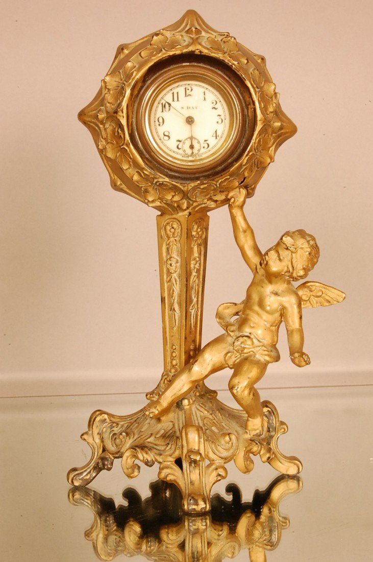 Art Noveau style shelf clock: Cherub seated at base. Gilted Spelter. 12" t x 6" d Ca. 1910