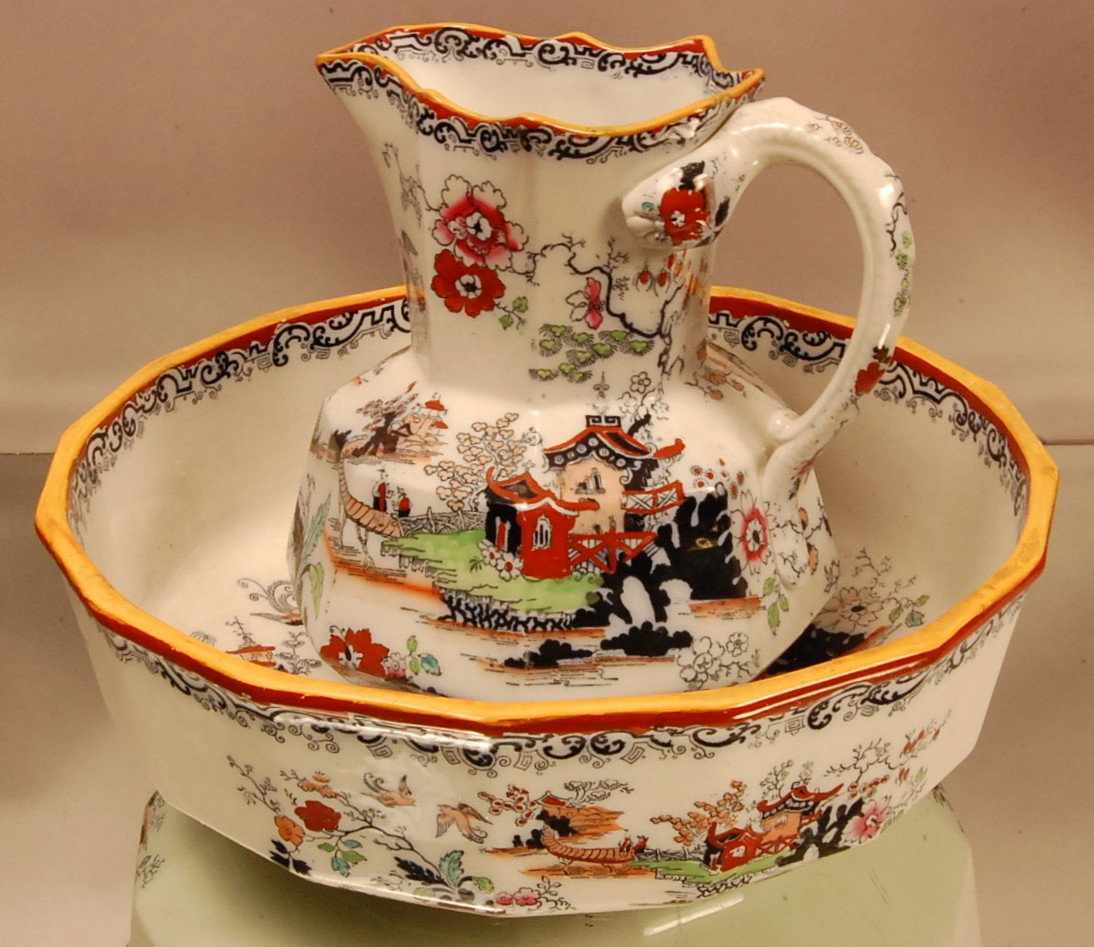 Masons Ironstone Bowl & Pitcher: Set with oriental village scenes. Hand painted on both pieces. Pitcher has serpent handle. Pitcher 11" t x 11" d, Bowl 16" d x 6" t. Has hairline crack on side. Ca. 1880