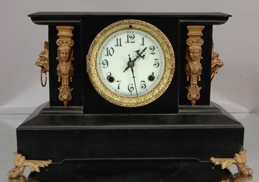 New Haven Iron Mantel Clock: Aesthetic movement style with ladies bust on sides. Lion heads & claw feet. Porcelain dial. Time & strike. 16" w x 10" t. Ca. 1890