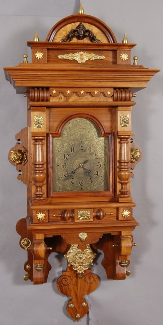 German Open Well Free Swinging Walnut Clock: Fancy Brass Dial & Pendulum. 8 Day Movement, Time & Strike. Brass Decorations on highly carved Walnut Case. Works signed Gustav Becker. # 1126612. 41" t x 18" w x 7" d. Ca. 1880