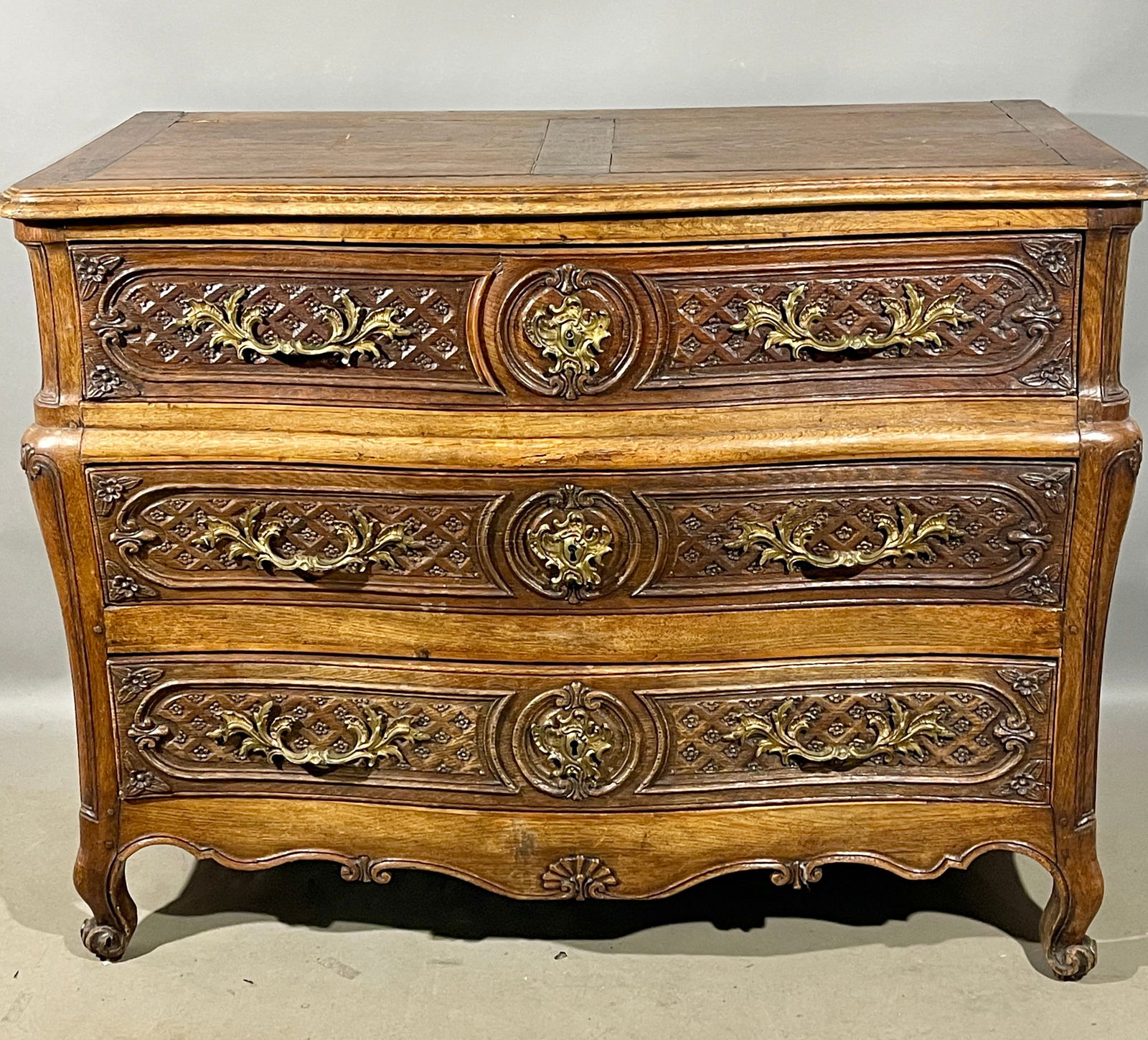 French LXV Commode: In oak, beautiful chest of drawers from the Louix LXV period, high quality, with bowed out front & sides, excellent floral carving on drawer fronts, original bronze hardware. Locks and keys for all dr