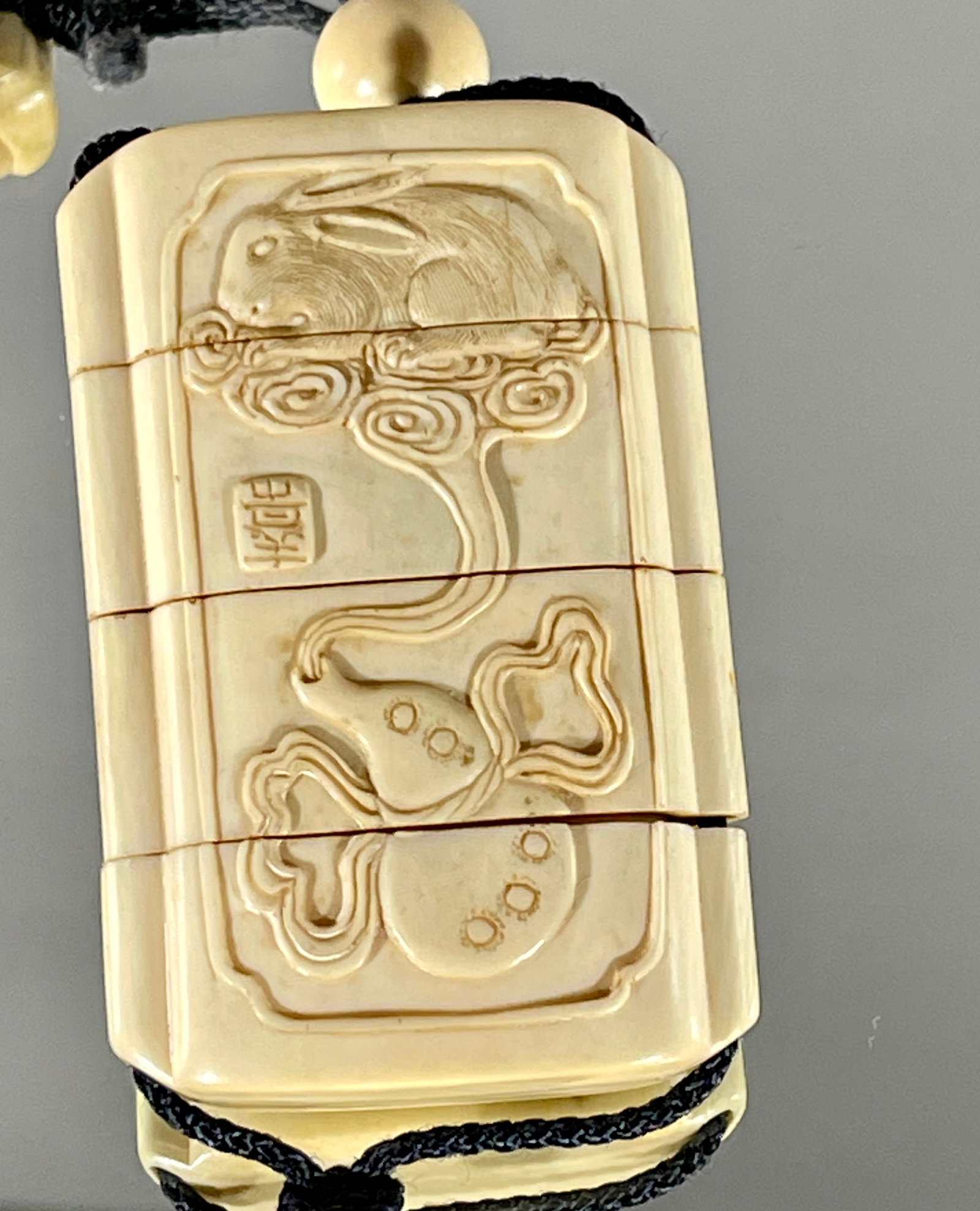 A Fine Japanese Inro: Three case, carved in walnut tusk, low relief with rabbitts & ducks & lily flowers, case is signed. Provenance: Purchased from a San Fransisco dealer by a Denver, Colorado collector. Ca. 20th century,