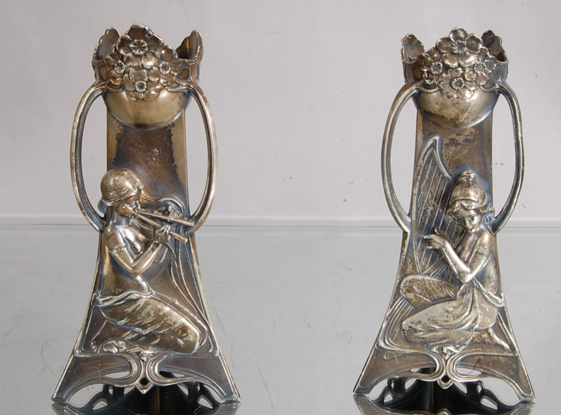 Art Noveau style vases.: Pair, silver plate, floral decoration on top, 3 handles, one with lady play harp, the other a flute. 7" t x 4" d. Ca. 1910