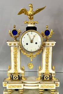French Louis XVI Bronze Mantel Clock: Ormolu and marble, eagle finail over 5" piolaine porcelain dial, blue crystal on toop a footed marble columns, acorn finail, sunburst dial, on fancy gilt bronze base, Silk String Movement, dial singed