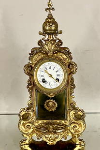 French Louis XVI Gilt Bronze Mantle Clock: Bronze finial on top of a floral decorated case, porcelain dial with roman numerals, 3 1/2"dial, sun burst pendelum with ladies face, works signed Vincent & Co., clock is in complete and running order