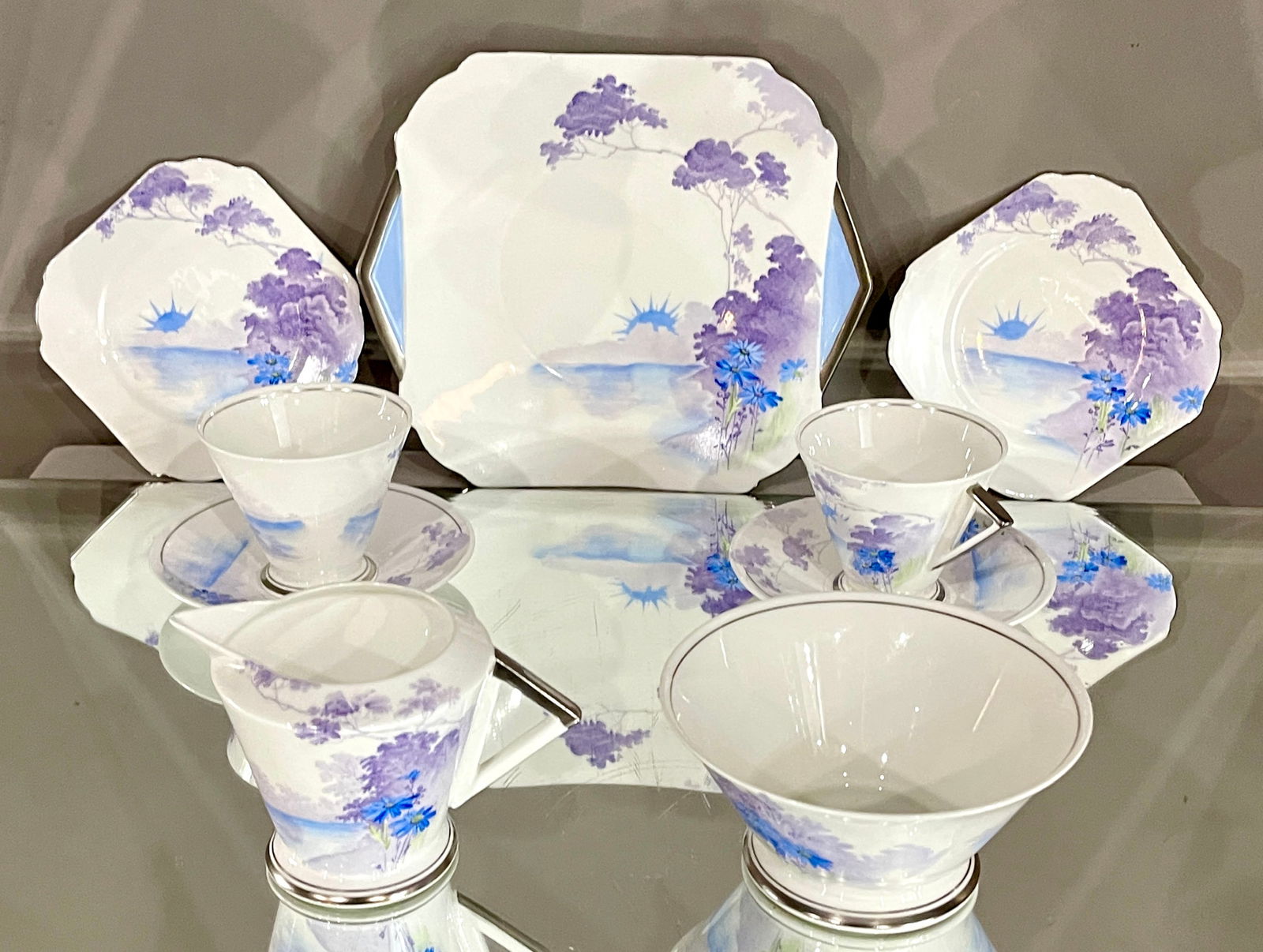 A Shelley Blue Art Deco 7 Piece Tea Set: Pattern #12282 CONDITION: 1 cup has been repaired DIMENSIONS: large plate 8 1/2" x 10", bread plates 5 1/2"w, sugar bowl 2 1/2"t x 5 1/2"w, creamer pitcher 3 1/2"t x 5 1/2"w, cups & saucers 3"t x 5