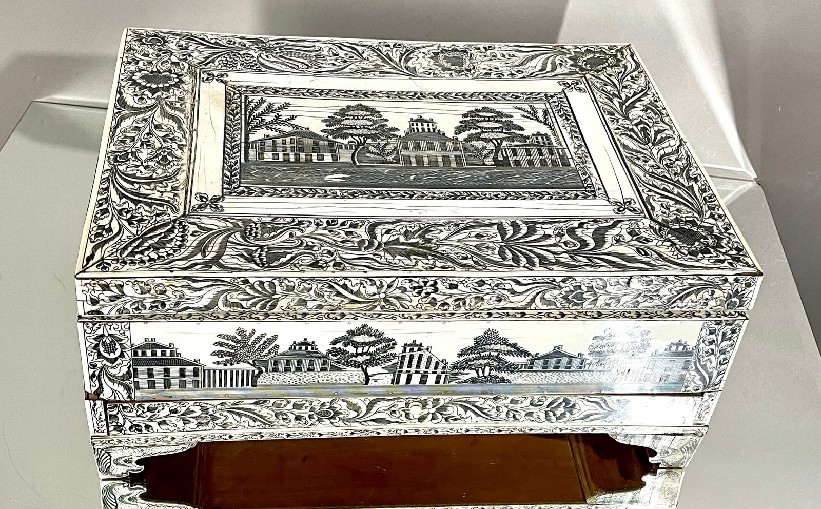 English Colonial Engraved Dressing Box: Rectangular form with a hinged lid, engraved with landscape, one drawer in base, engraved on all sides, ogee bracket feet, bone construction. DIMENSIONS: 7 1/2"t x 12 1/2"d x 17"w. Vizagapatam. CIRCA: