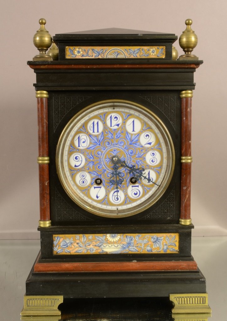 French Empire style marble mantel clock: Bronze finials, floral decorated panel, marble columns, porcelain dial. Time & double gong strike. 18" t x 12" w. Signed John Walker. Paris. Ca. 1875