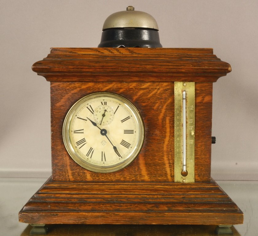 Ansonia Hotel Model Alarm Clock: Ansonia Hotel Model Alarm Clock with battery operated alarm bell. Quartered Oak Case with thermometer on side. 11"hX11"w. ca. 1900.