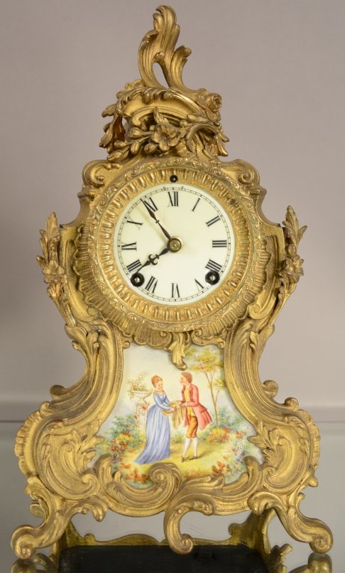 Ansonia Louis XV Style Gilted Mantel Clock: Ansonia Louis XV style gilted mantel clock with serves hand decorated panel. Porcelain dial. Time and Strike. Works signed Ansonia. ca. 1890. 15" tall x 8" wide