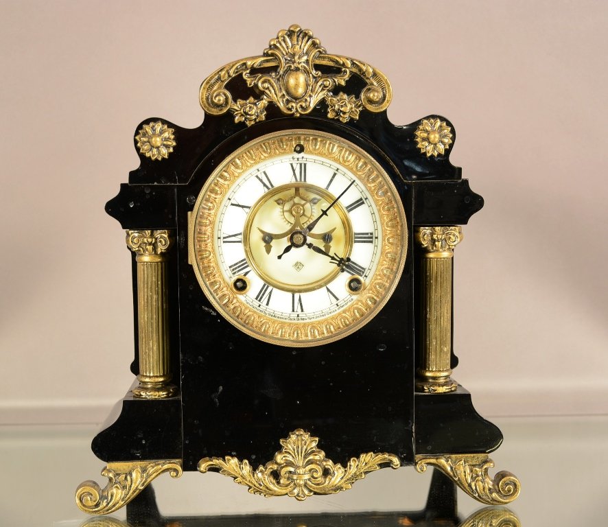 Ansonia Enameled Mantel Clock: Ansonia enameled mantel clock. Iron case with brass trim. Porcelain dial with open escapement. Time and strike. Works signed Ansonia. ca. 1900. 11" tall x 10" wide