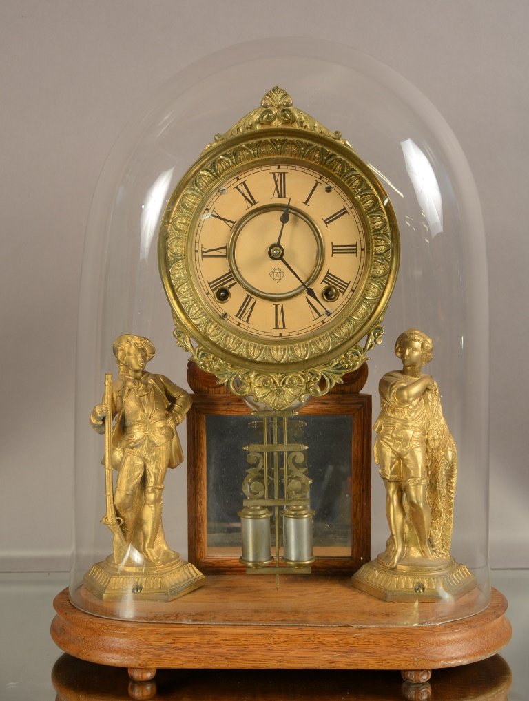 Ansonia Crystal Palace Parlor Clock: Ansonia crystal palace parlor clock. Double figural statues under glass dome. Time and bell strike. Oak frame. ca. 1880. 18" tall x 14" wide