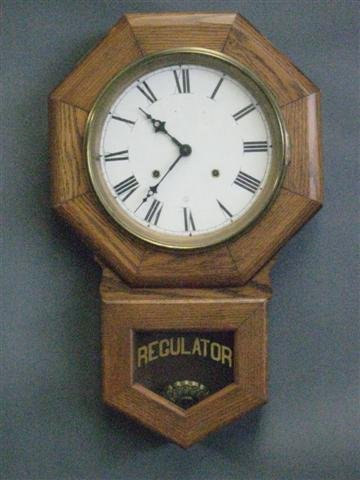 Clock, Oak Schoolhouse Type, Dial with Sessions T: Clock, Oak Schoolhouse Type, Dial with Sessions Trademark, 8 Day Time and Strike, 23 1/4'' H x 14 1/2'' W, Appears to be Restored, $50-$125.