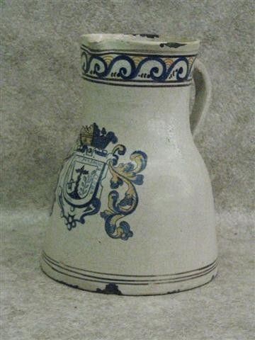 Talavera Faience Pitcher, Scroll Border, Coat of Ar: Talavera Faience Pitcher, Scroll Border, Coat of Arms on Front, 11 1/2'' H x 9'' Dia. (at Base), Some Chips to Glaze and Pitcher, Some Breaks and Repairs, $150-$250. Talavera Pottery of Puebla, Mexico