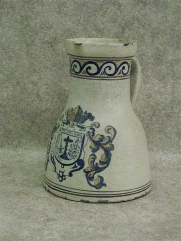 Talavera Faience Pitcher, Scroll Border, Coat of Ar: Talavera Faience Pitcher, Scroll Border, Coat of Arms on Front, 10 1/2'' H x 7 3/4'' Dia. (at Base), Some Chips to Glaze and Pitcher, $100-$250. Talavera Pottery of Puebla, Mexico is a type of majolic