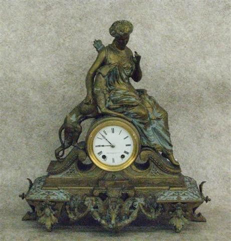 Clock, Figural, Seth Thomas Sons & Co./New York as: Clock, Figural, Seth Thomas Sons & Co./New York as Marked on Porcelain Dial, 8 Day Time and Strike, 19'' H x 18'' W x 7'' D, $200-$400.