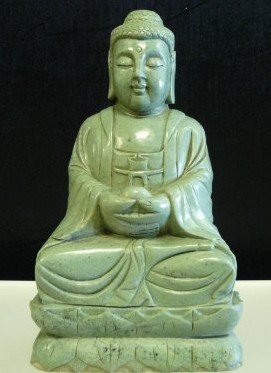 LARGE JADE SITTING BUDDHA: SKU: A69This Sitting Buddha is made from one solid piece of jade. Very detailed carvings. It appears light green with some spots dark green. All hand carved with natural stones. Size: Wide: 12", Deep: