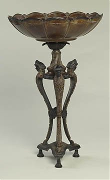 Bowl on pedestal: Code: 51653 Brown marble-like painted metal has verdigris finish accents and three ladies heads featured on the base Dimensions: 21.00 H, 13.00 W, 13.00 D