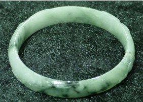 BURMESE JADEITE CARVED BRACELET: SKU: JP51is bracelet is made from one solid piece of BURMESE JADEITE. All natural color. It appears light green with some spots dark green. It is transparent. Flowers are carved on the surface. Wearin