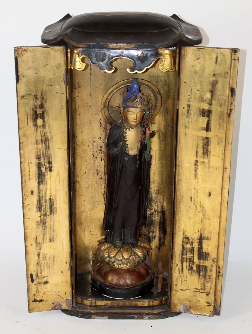Buddhist icon in cabinet: Buddhist icon in cabinet. Carved wood. 37"h x 17"w x 7"d