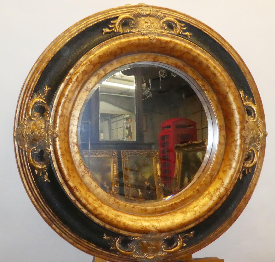 Round black and gold framed beveled mirror