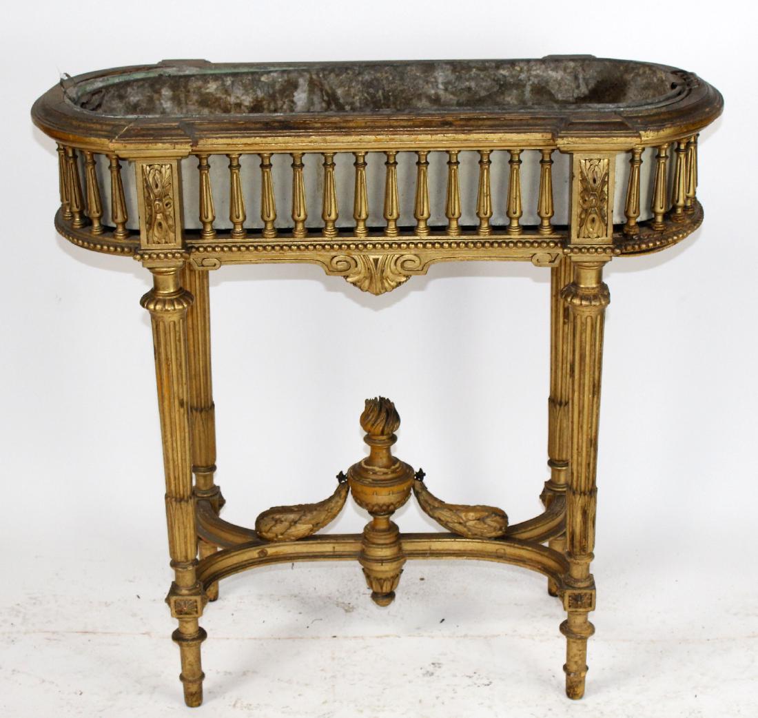 French Louis XVI giltwood jardiniere: French Louis XVI giltwood jardiniere. On tapered fluted legs. Cross stretcher having urn with flame. 19th century. 33"h x 36"w x 13"d