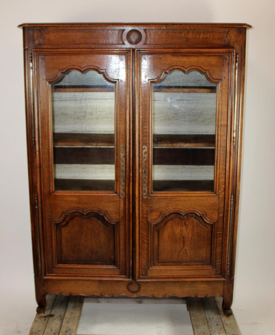 French oak armoire with glass doors.