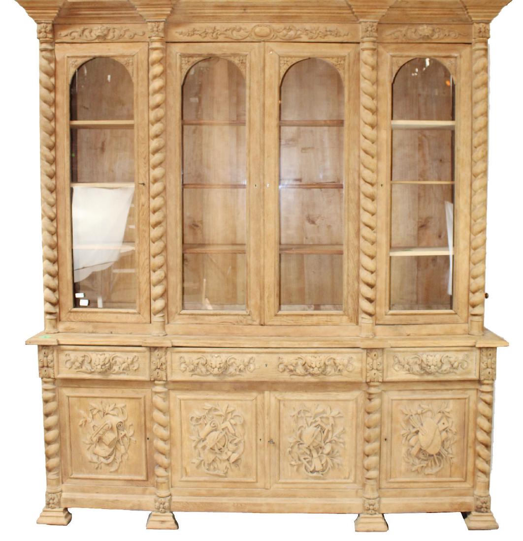 French bleached oak 4 door bookcase: French bleached oak 4 door bookcase. Barley twist columns and relief carved lower doors depicting attributes of the arts and science. Late 19th century. 97 1/2"h x 87"w X 24"d
