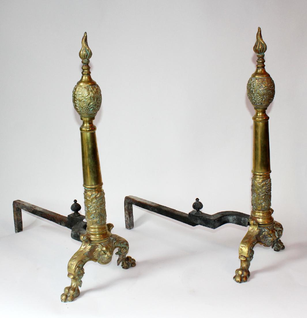 Pair of decorative brass andirons: Pair of decorative brass andirons. Early 20th century. 24"h x 10 1/2"w x 20"d