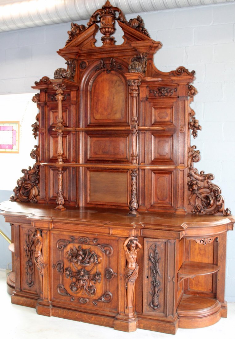 French Renaissance buffet in black oak: Monumental French Renaissance sideboard in black oak. The lower cabinet has figural caryatids flanking a focal, relief carved door with various flora, game birds and wheat fronds. The caryatids give r