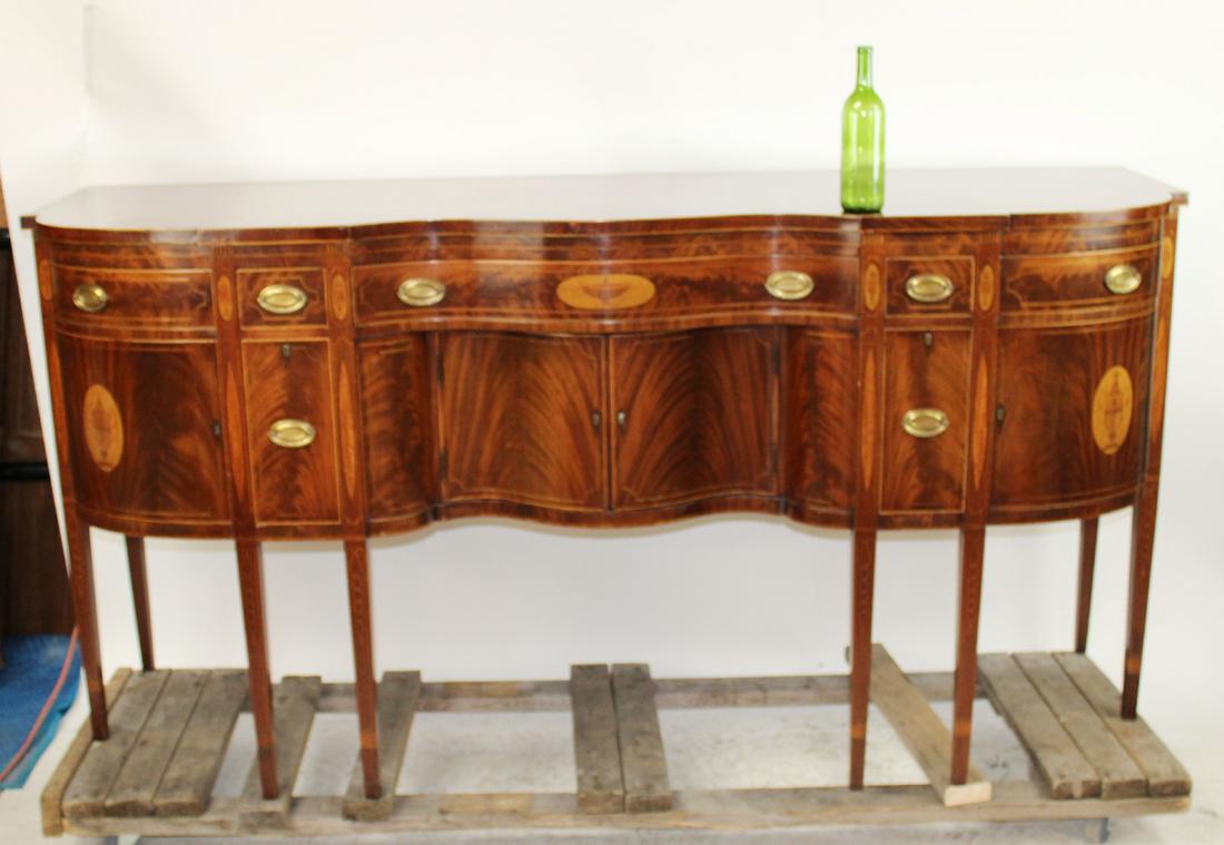 Hepplewhite serpentine sideboard in mahogany: Hepplewhite serpentine sideboard in mahogany and flame mahogany with inlaid urns. 2 drawers have cellarette. Early 20th century. 42 1/4"h x 84"l x 26"d