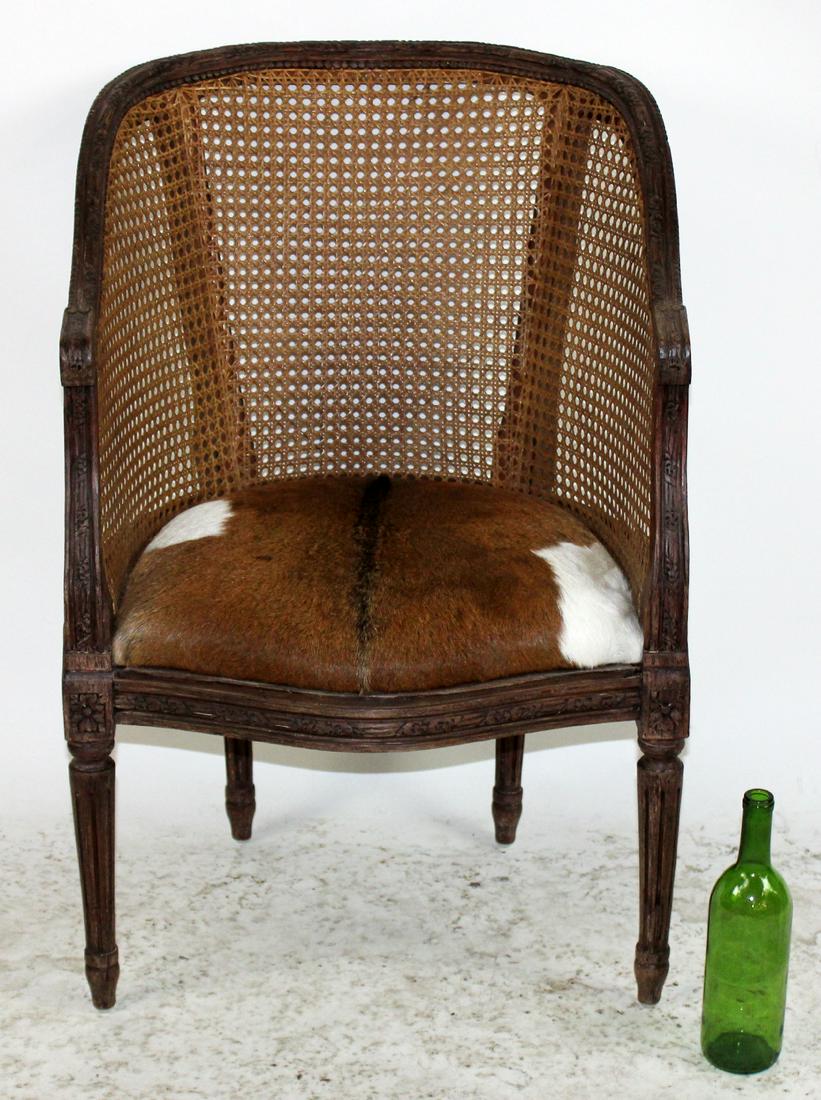 Louis XVI style curved back barrel chair: Louis XVI style curved back barrel chair with cane back and cow hide seat. 33 1/4"h x 22"w x 25"d