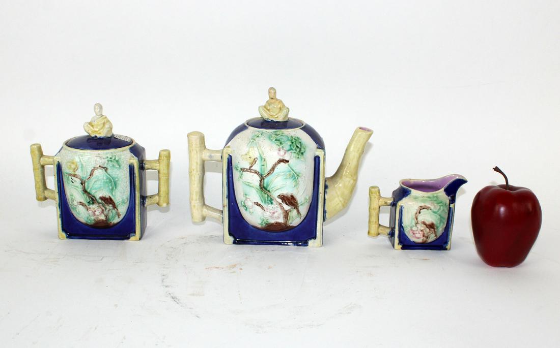 English Majolica 3pc tea service: English Majolica 3pc tea service. Faux bamboo handles, decorated with cherry blossoms and birds. Late 19th century. Tea pot with lid 7.75"h x 8.75"w x 4.75"d Sugar with lid 6.25"h x 7"w x 3.75"d Cream