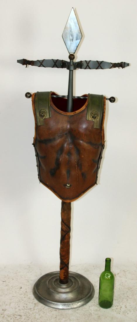 Leather & brass sculpture of Gladiator vest: Leather & brass sculpture of Gladiator vest with lion heads. On iron stand. 21st century. 59"h x 29"w x 15"d