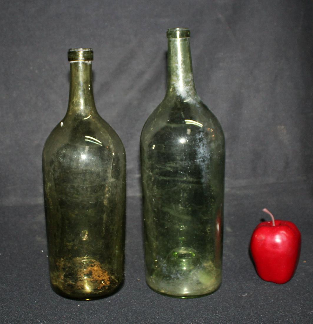 2 French glass wine bottles: 2 French glass wine bottles. 14"h and 15"h. Early 20th century.