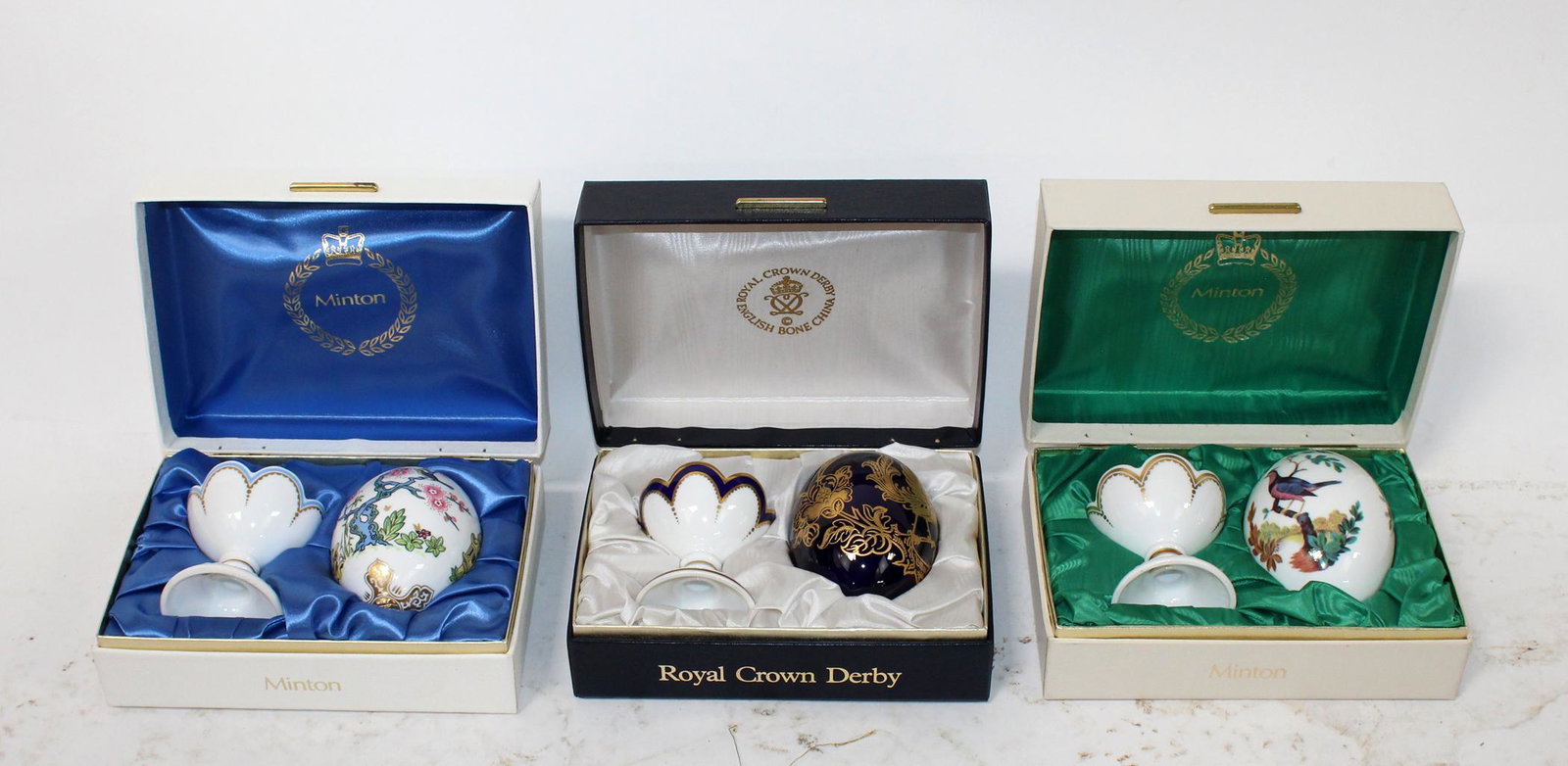 Porcelain eggs by Minton and Royal Crown Derby.: Lot of 3 porcelain eggs made by Minton and Royal Crown Derby. Eggs 5 1/2"h x 3"dia, box 3"h x 7 1/2"w x 5 1/2"d